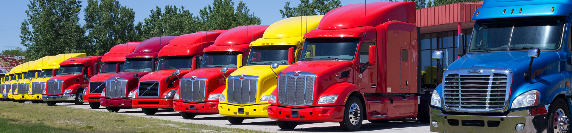 Red, yellow and blue semi trucks lined up in a row