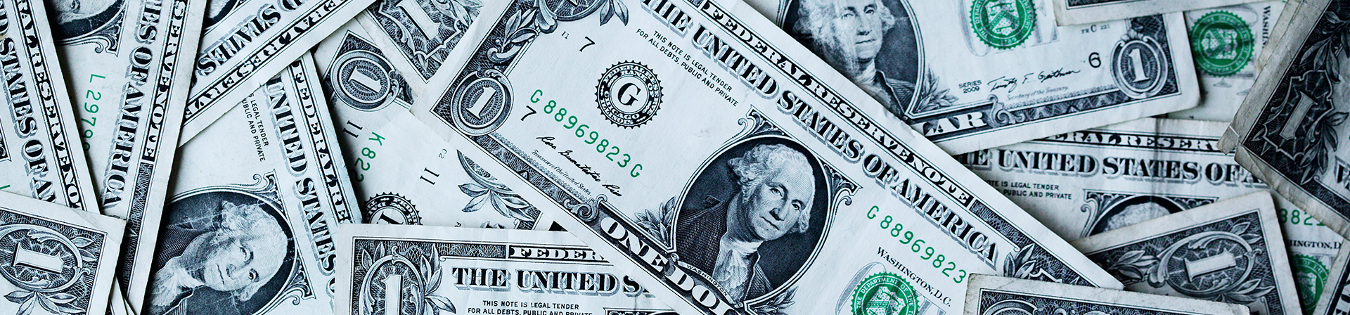 Dollar bills strewn around in a pile representing taxes