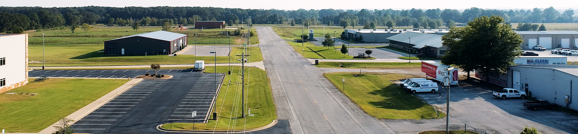 Looking down the street through Henry Jones III Business Park showing buildings and parking lots