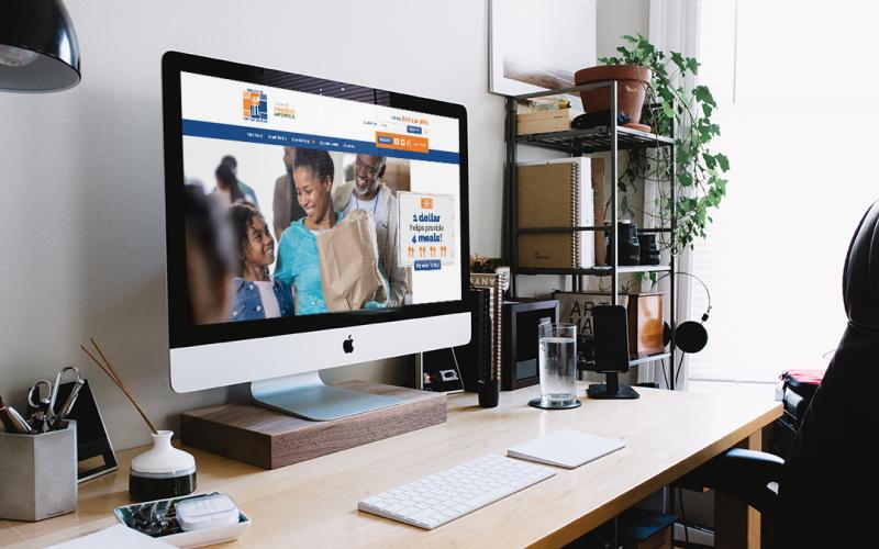 Mockup of Food Bank of NEA website on Mac desktop computer sitting on desk