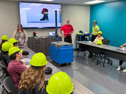 TekStarz campers wearing hard hats and listening to person talk from BEST Manufacturing in Jonesboro
