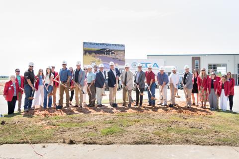 Officials, partners and supporters standing with shovels full of dirt in the groundbreaking for the Jonesboro Municipal Airport Commercial Terminal