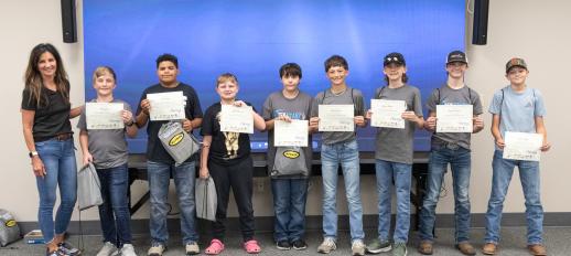 Students standing in a row holding their TekStarz completion certificates 